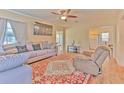 Cozy living room with a large sectional sofa, ceiling fan, and hardwood flooring at 5939 14Th St, Zephyrhills, FL 33542