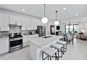 Modern kitchen with stainless steel appliances, quartz countertops, and a center island with seating at 6137 Wire Grass Ct, Nokomis, FL 34275