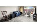 Living room with comfortable seating, including a blue sofa and rocking chair at 710 N Village N Dr # 102, St Petersburg, FL 33716