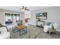 Bright living room featuring tile flooring, a ceiling fan, and sliding glass doors to the outside at 7242 55Th N Ave, St Petersburg, FL 33709