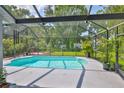 Beautiful screened-in pool and patio area with lush landscaping providing privacy, perfect for outdoor enjoyment at 7649 Nottinghill Sky Dr, Apollo Beach, FL 33572