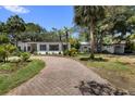 Well-maintained single-story home with a circular driveway and mature trees at 8239 26Th N Ave, St Petersburg, FL 33710