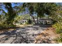 Classic single-story home with a carport and tree-lined driveway at 8239 26Th N Ave, St Petersburg, FL 33710