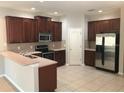 Well-lit kitchen featuring stainless steel appliances, wood cabinets, and tile flooring at 10402 Tulip Field Way, Riverview, FL 33578