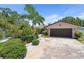 Inviting single-story home with lush tropical landscaping and a two-car garage at 10515 Hetrick W Cir, Largo, FL 33774