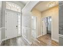 Bright foyer featuring wood-look floors, a modern chandelier, decorative wall accents, and an arched doorway at 10855 Cory Lake Dr, Tampa, FL 33647