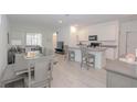 Open-concept kitchen and dining area featuring white cabinets, gray countertops, and modern appliances at 11830 Brighton Knoll Loop, Riverview, FL 33579