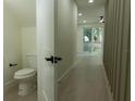 Hallway with a peek into the half bathroom including a toilet at 12484 Cross St, Largo, FL 33773