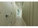 Long hallway featuring wood floors and modern decor with a view of the backyard at 12484 Cross St, Largo, FL 33773