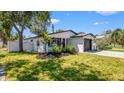 Beautifully landscaped home with black trim, brick driveway, and a well-maintained lawn at 1710 Shore Acres Ne Blvd, St Petersburg, FL 33703
