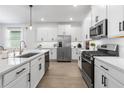 Modern kitchen with white cabinets, stainless steel appliances, and a large center island at 17249 Star Banks St, Wimauma, FL 33598