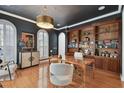 Stylish home office featuring custom built-ins, a striking light fixture, and wood floors at 1940 Floresta View Dr, Tampa, FL 33618