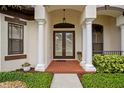 Inviting front entrance with double doors, white columns, and well-manicured landscaping at 19830 Strathmore Pl, Land O Lakes, FL 34638