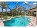 Screened-in pool and hot tub with sunny backyard and patio seating area, perfect for outdoor relaxation at 19830 Strathmore Pl, Land O Lakes, FL 34638