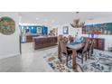 Open-concept dining area featuring an antler chandelier, decorative rug, and seamless flow to the kitchen at 1990 59Th N St, St Petersburg, FL 33710