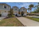 Attractive townhome with two-car garage, tidy front lawn, and a modern vehicle parked in the driveway at 2013 Sunset Wind Loop, Oldsmar, FL 34677