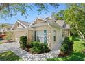 Lovely single-Gathering home featuring a two-car garage, neutral exterior paint, and lush landscaping at 20221 Vintage Oaks Pl, Tampa, FL 33647
