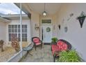 Inviting and cozy front porch with decorative decorations and outdoor seating arrangement with tiled floors at 2216 W Del Webb Blvd, Sun City Center, FL 33573
