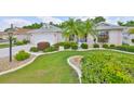 Well-maintained lawn and tropical landscaping accent this single Gathering home with an attached garage and paver driveway at 2216 W Del Webb Blvd, Sun City Center, FL 33573