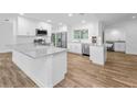 Modern kitchen with white cabinets, stainless steel appliances, and wood-look tile flooring at 3079 Osprey Ln, Clearwater, FL 33762