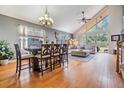 Spacious living room and dining area with hardwood floors, large windows, modern lighting, and neutral color scheme at 30817 Pumpkin Ridge Dr, Wesley Chapel, FL 33543