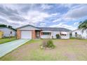 Charming single-story home with a brick facade, one-car garage, and well-maintained front yard at 39423 9Th Ave, Zephyrhills, FL 33542