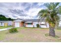 Charming single-story home with a brick facade, one-car garage, and a mature palm tree at 39423 9Th Ave, Zephyrhills, FL 33542