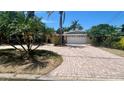 Inviting exterior view of home with a paved driveway, two-car garage, and mature palm trees at 4772 Dover Ne St, St Petersburg, FL 33703