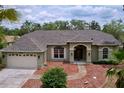 Inviting single-story home with a well-maintained lawn, mulch landscaping, and a covered front porch at 5058 Westlake Blvd, Dade City, FL 33523