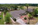 Aerial view of a beautiful home with mature trees, lake view, well-maintained lawn and mulch landscaping at 5058 Westlake Blvd, Dade City, FL 33523