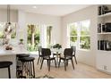 Bright and inviting dining area with large windows and a table for four, adjacent to the kitchen at 6 Simonton Ave, North Port, FL 34286
