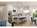 Bright kitchen features an island with seating, stainless appliances, and modern pendant lighting at 6 Simonton Ave, North Port, FL 34286