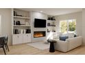 Cozy living room features custom built-in shelving, contemporary fireplace, and large window for natural light at 6 Simonton Ave, North Port, FL 34286