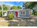 Cozy gray home featuring a red front door, bright windows, and tidy yard at 601 Newton S Ave, St Petersburg, FL 33701
