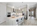 Modern kitchen with a large island, stainless steel appliances, pendant lighting, and stylish countertops at 6017 Silver Grass Ct, Nokomis, FL 34275