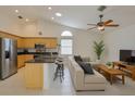 Open-concept living room and kitchen with stainless steel appliances and a breakfast bar with seating at 6332 35Th Avenue E Cir, Palmetto, FL 34221