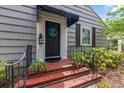 Close-up of the front door with a black awning and brick steps at 720 39Th N Ave, St Petersburg, FL 33703