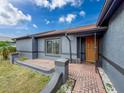Inviting front entrance with a brick walkway leading to a covered porch area at 7237 Bramblewood Dr, Port Richey, FL 34668