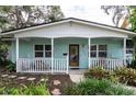 Charming single-story home with a quaint front porch, lush landscaping, and a welcoming entrance at 7842 15Th N Way, St Petersburg, FL 33702
