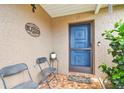 Welcoming front porch with tiled floor, seating, and a charming blue door, complete with decorative accents at 8225 Medford Dr, Port Richey, FL 34668