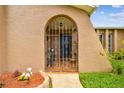 Inviting front entrance with a decorative metal gate leading to a tiled porch area of this lovely home at 8225 Medford Dr, Port Richey, FL 34668