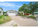 Charming single-story home featuring a brick driveway, two-car garage, and well-kept landscaping at 8407 Hunters Fork Loop, Ruskin, FL 33573