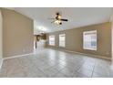 Bright living room with tile floors and multiple windows, flowing into the kitchen at 925 Windton Oak Dr, Ruskin, FL 33570