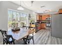 Eat-in kitchen with stainless appliances, wood cabinetry, and a large window offering serene views of the backyard and patio at 9401 Willow Cove Ct, Tampa, FL 33647