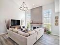 Bright living room featuring vaulted ceilings, a modern fireplace, neutral sectional, and large windows overlooking the property at 9401 Willow Cove Ct, Tampa, FL 33647