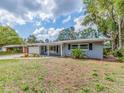 Inviting single-story home with a covered front porch and beautiful landscaping in the front yard at 949 Virginia St, Dunedin, FL 34698