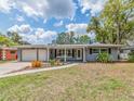 Well-maintained home featuring a gray exterior, a driveway, and colorful landscaping at 949 Virginia St, Dunedin, FL 34698