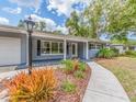 Charming home with covered porch, decorative landscaping, and walkway to the entrance at 949 Virginia St, Dunedin, FL 34698