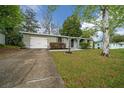 View of a single-story home with an attached garage and a concrete driveway at 9613 River Rd, Spring Hill, FL 34608