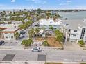 Aerial view of a coastal home with a screened in pool and proximity to the ocean, shops, and restaurants at 101 11Th Ave, St Pete Beach, FL 33706